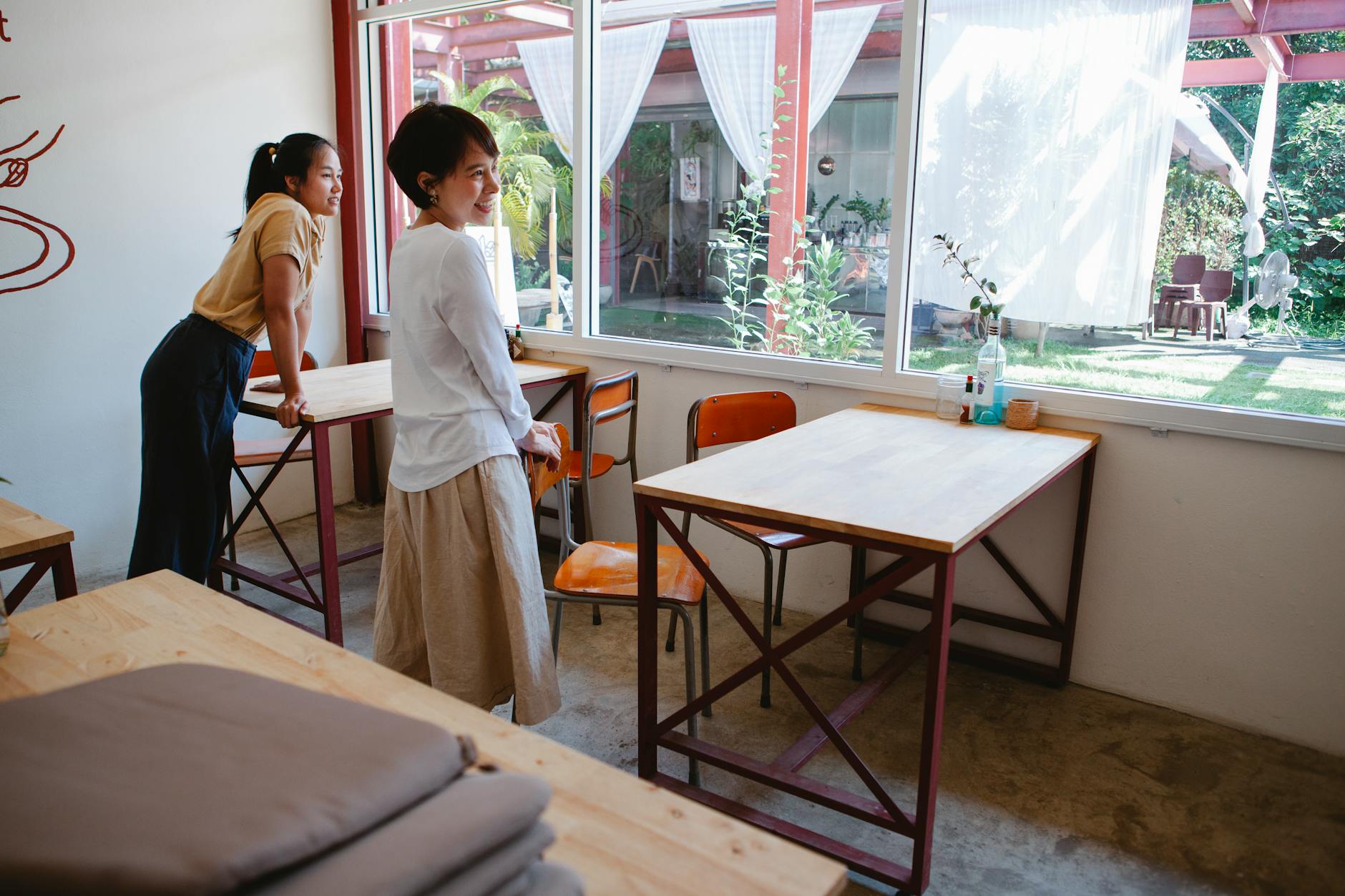 women standing near tables and chairs